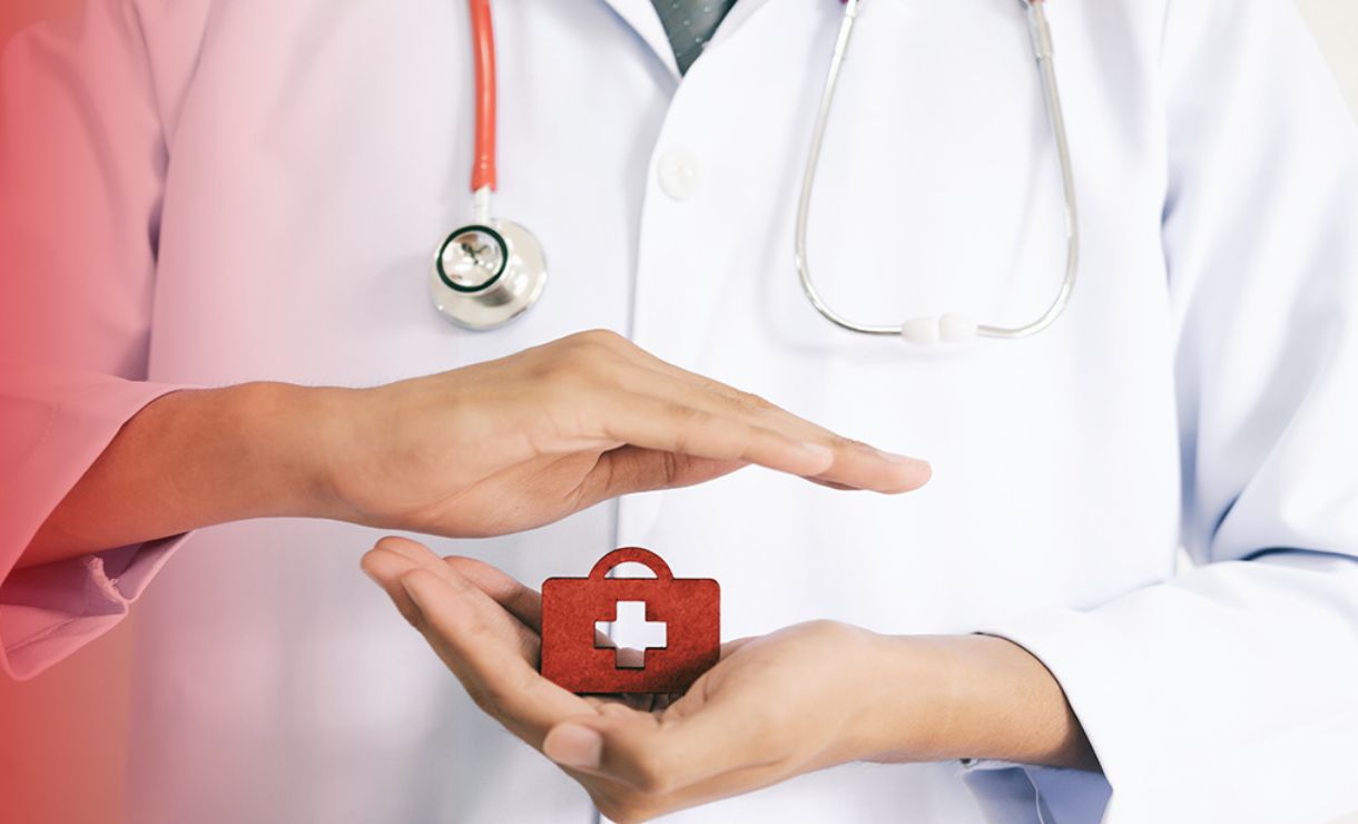 Mão com ícone de cruz médica vermelha simbolizando proteção à saúde